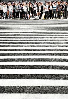 a group of people standing in the middle of a cross walk