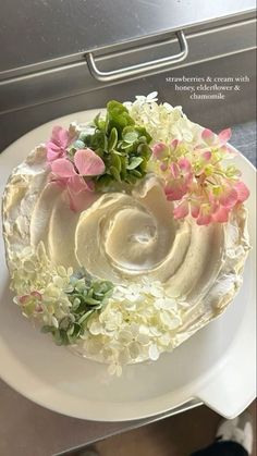 there is a cake with flowers on the top and frosting in the middle, sitting on a white plate