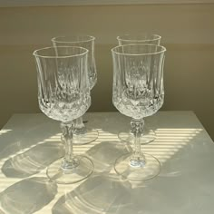 two clear glass goblets sitting on top of a white countertop next to each other