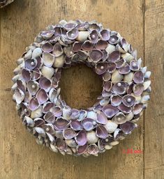 a wreath made out of seashells sitting on top of a wooden table