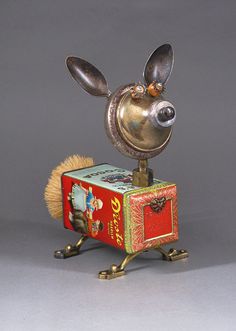 a metal toy with a mouse on it's head and an open box in the shape of a chest