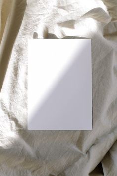 an empty white card sitting on top of a bed