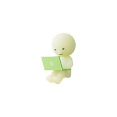 a small toy sitting on top of a laptop computer next to a green object in the air