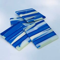 four blue and white striped glass coasters