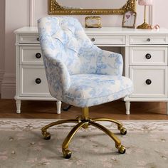 a blue and white chair sitting in front of a mirror on top of a dresser