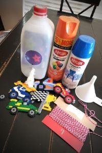 the table is covered with crafting supplies such as plastic bottles, scissors and glue