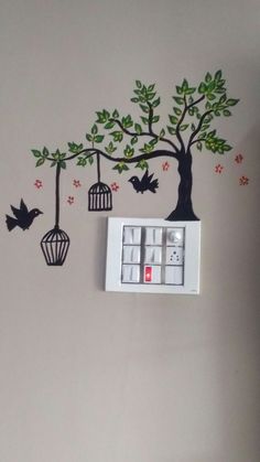 there is a clock on the wall with birds in cages hanging from it's branches