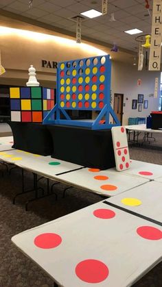 a room filled with lots of tables covered in different colored dots and shapes on top of them