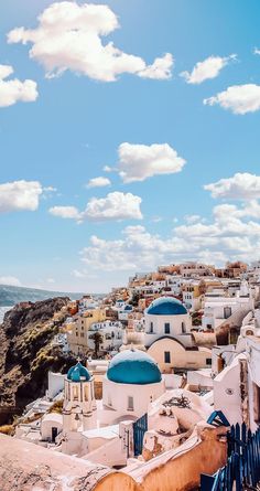 a view of some buildings on the side of a hill with clouds in the sky