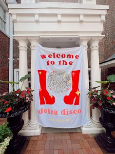 welcome to the delta disco banner in front of a building with potted plants on either side