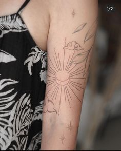 a woman's arm with a sun and stars tattoo on the left side of her arm