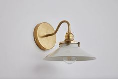 an old fashioned brass wall light with white glass shade