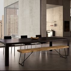 a wooden bench sitting in front of a large window next to a table with two bananas on it