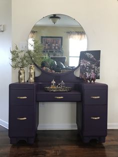 a purple vanity with a mirror and vases on it