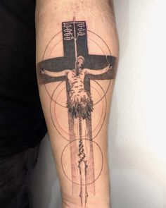 a man's leg with a cross tattoo on it and an image of jesus