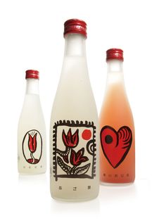 three bottles with designs on them sitting next to each other