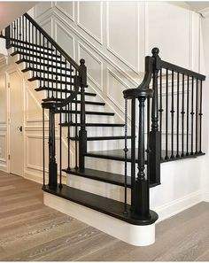 a black and white stair case next to a wooden floor