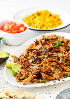 pulled pork with cilantro, avocado and salsa on a white plate