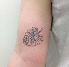 a black and white tattoo on the arm of a person with a flower in it