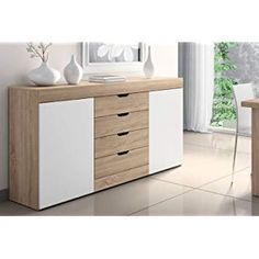 a white and wood dresser with three vases on it's sideboard next to a window