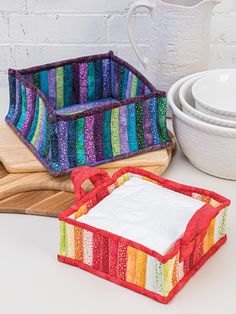 three pieces of colorful fabric sitting next to each other on top of a white table