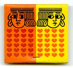 an orange and yellow box with two faces painted on the side, surrounded by hearts