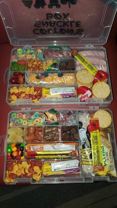 two clear plastic containers filled with snacks and crackers on top of a red table