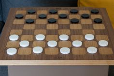 a close up of a board game on a wooden table with white and black pieces