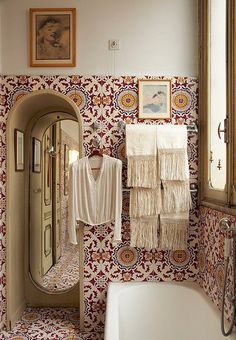 a bath room with a tub and a mirror on the wall next to a sink