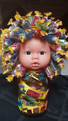 a doll with candy on its head in a jar