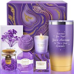 a purple gift box with candles, lavenders and an open candle in front of it