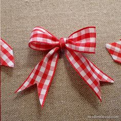 red and white checkered ribbon tied to the side of a piece of cloth with two smaller bows