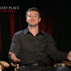 a man sitting in a chair with his hands out and the words quiet place on it