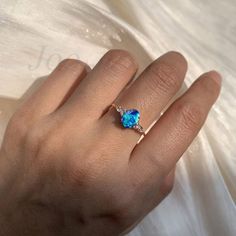 a woman's hand with a blue ring on it