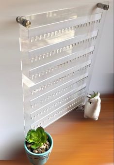 a potted plant sitting next to a radiator on top of a wooden table