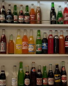 many different types of sodas are on the shelves