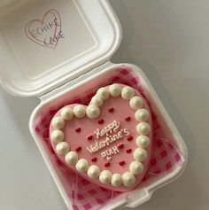 a heart shaped cake in a pink and white container with writing happy valentine's day