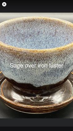 a blue and brown bowl sitting on top of a saucer with the words sage oven iron lustter