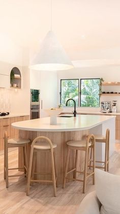 a kitchen with an island and stools in it