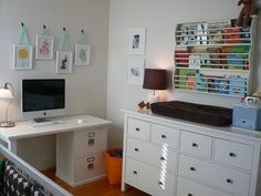 a white desk sitting in the middle of a room next to a dresser and computer monitor