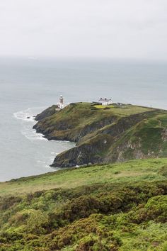 a lighthouse on top of a hill near the ocean