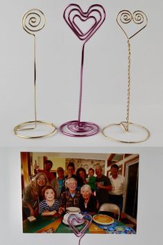 an image of two metal hearts on top of a table with people in the background