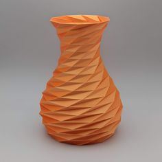 an orange vase sitting on top of a table