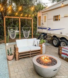 an outdoor living area with couches, chairs and a camper