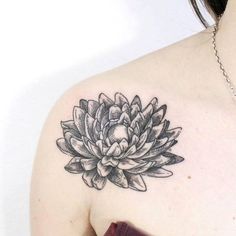 a woman's chest with a flower tattoo on it