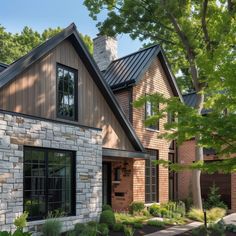 a large brick house surrounded by trees and plants in front of it's windows