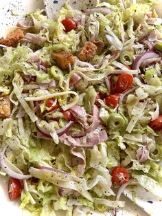 a salad with lettuce, tomatoes and meat on it