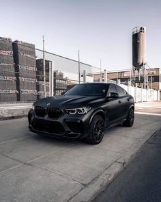 a black bmw suv parked in front of a building