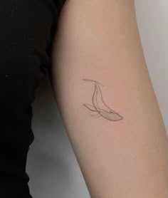 a woman's arm with a tattoo that has a line drawing of a bird on it