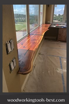 an empty room with large windows and wooden flooring on the side of the wall